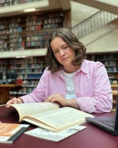Jessica Urwin at the State Library of NSW reading a book